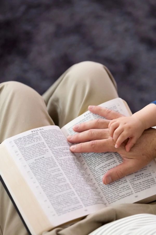 Adult and child reading from an open Bible together