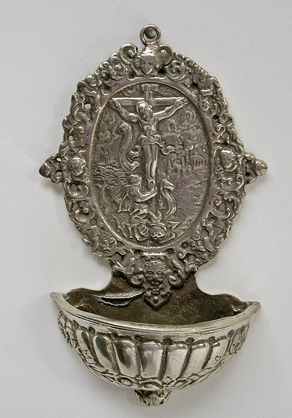 Decorative Catholic holy water font with a Crucifixion image