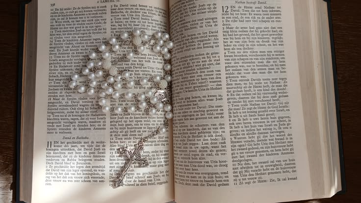 Rosary resting on an open Bible