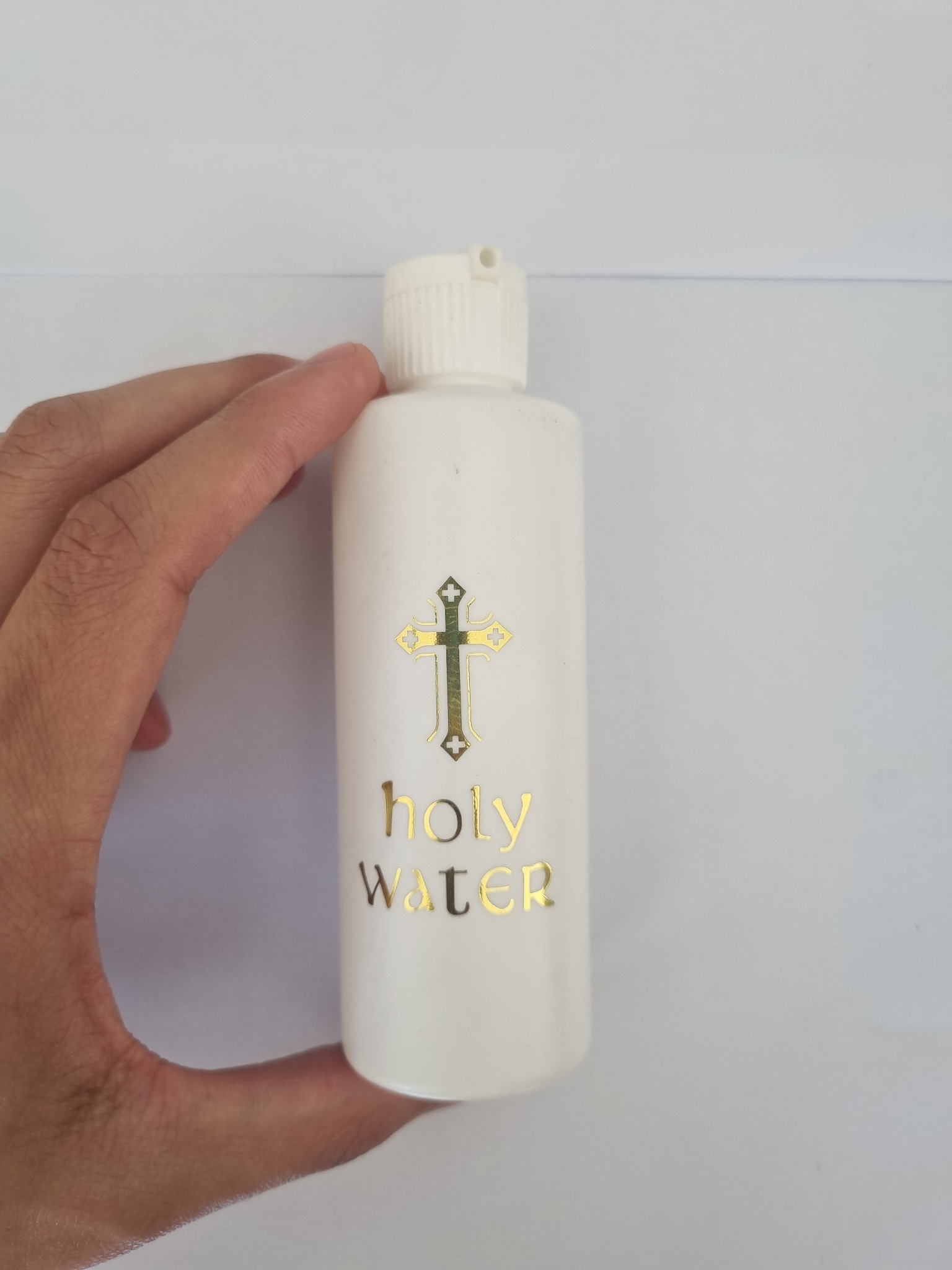 Small white holy water bottle with gold cross and Holy Water text