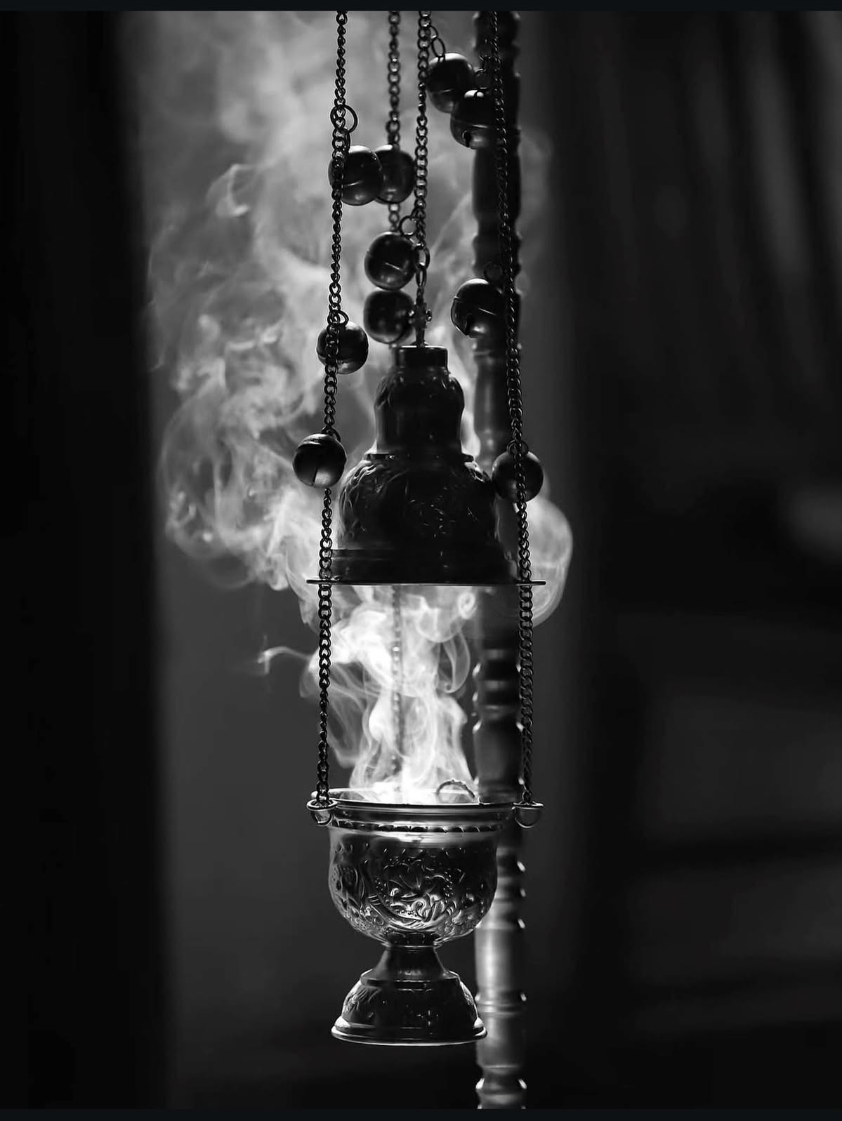Black and white image of a thurible surrounded by incense smoke