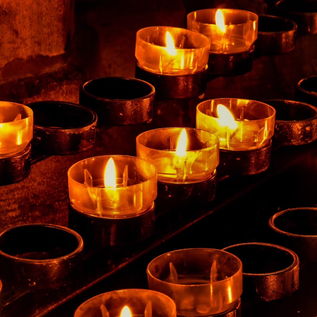 Lit votive candles glowing in a Catholic church